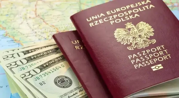 Dwa polskie paszporty i banknoty dolarowe na mapie. Czy do Szwajcarii potrzebny jest paszport? Tak, jeśli nie jesteś obywatelem UE.