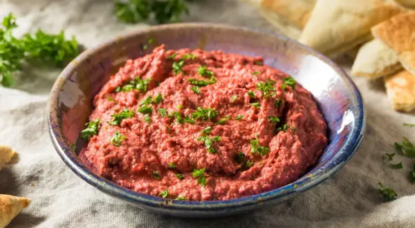 Pyszna pasta z czerwonej fasoli, posypana natką pietruszki, podana z kawałkami pity.