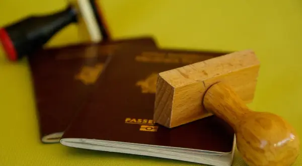 Pasporty i pieczątki, symbolizujące podróże, ale też potencjalną deportację.