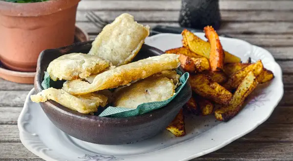 Knusprige Fischstücke in Tempurateig, daneben Pommes Frites. Ein Genuss, der zeigt, was ist Tempurateig.