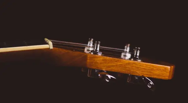Drewniana główka gitary klasycznej z widocznymi kluczami strojeniowymi. Idealne miejsce, by zacząć naukę, jak nastroić gitarę klasyczną.