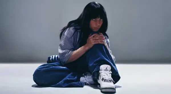 Billie Eilish w luźnych jeansach i stylowych sneakersach, jakby przygotowywała się do koncertu w Polsce.