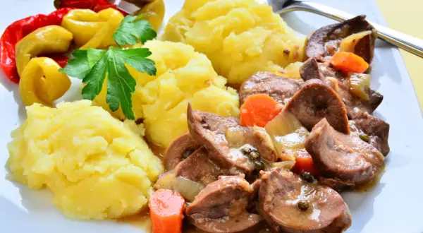 Cynaderki duszone z marchewką i cebulą, podane z puree ziemniaczanym i pikantnymi papryczkami. Pyszne danie, co to za smak!