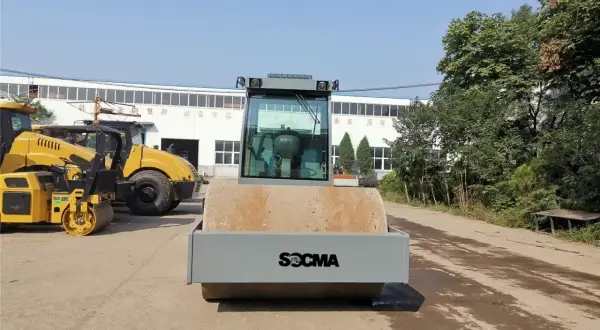 Nowe maszyny do robót ziemnych, w tym walec drogowy SOCMA, czekają na pracę.