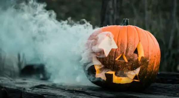 Dym wydobywa się z wyciętej dyni, która wygląda jakby czekała na Halloween.