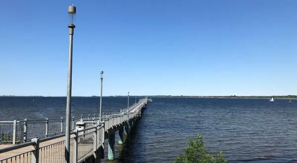 Langer Steg am Wismar Strand, der ins tiefblaue Wasser führt. Ein perfekter Ort für einen Spaziergang.