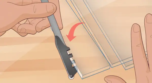 Hands demonstrate how to cut glass with a scoring tool, creating a clean line on the material.