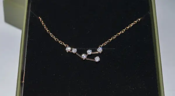 Colgante Tauro con circonitas brillantes en una caja verde.