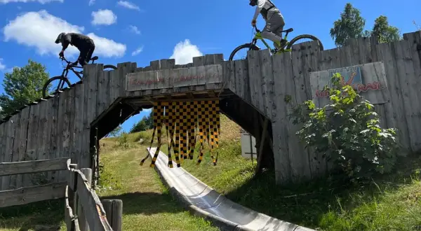 Två cyklister på en träbro i en bikepark i Tyskland. En perfekt plats för en äventyrlig semester.
