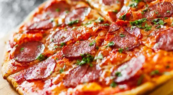 Pyszna pizza bez drożdży z pikantnym salami i posypką z ziół. Idealna na szybki obiad.