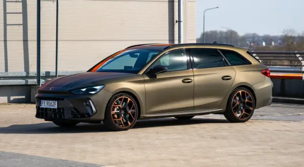 Złoty Cupra Leon Kombi z miedzianymi akcentami na felgach i dachu, zaparkowany na zewnątrz.