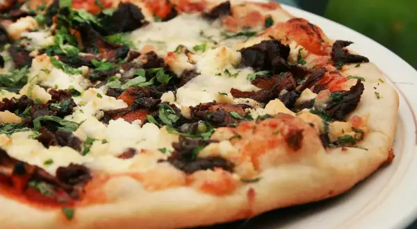 En härlig napolitansk pizza på grillen, med mörka svampar och krämig ost.