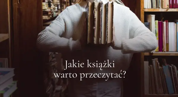 Kobieta w swetrze trzyma stos starych książek w bibliotece. Jakie książki warto przeczytać?