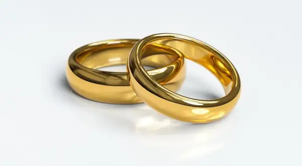 Dwa złote obrączki, symbol miłości. Zastanawiasz się, ile kosztuje gram złota 585 u jubilera?