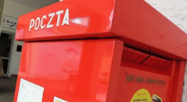 Czerwona skrzynka pocztowa z napisem "POCZTA". Warto pamiętać o poprawnym wpisaniu kodu pocztowego Toruń, aby list trafił do adresata.