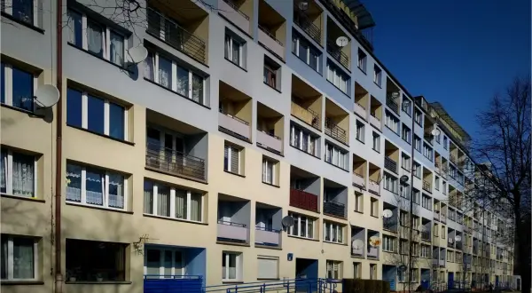 Blok mieszkalny z balkonami i antenami satelitarnymi. Idealne miejsce, gdzie szukać tanich mieszkań, jeśli cenisz sobie widok na miasto.