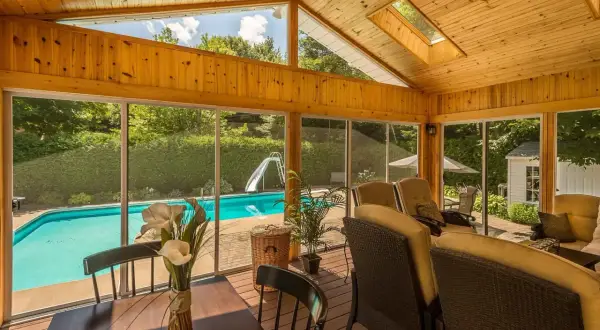 Porche de madera con vistas a piscina y tobogán. Ideal para aprender como hacer un porche de madera y disfrutar del verano.