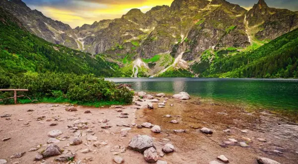 Górskie jezioro otoczone zielenią i skalistymi szczytami, idealne miejsce na pomysł na wakacje.