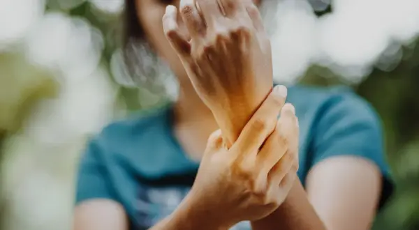 Mano che si tiene il polso, forse per un dolore ai legamenti del polso.