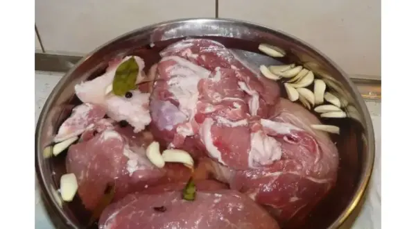 Mięso w misce z zalewą, czosnkiem, liśćmi laurowymi i pieprzem. Idealne do marynaty do mięsa do wędzenia przepis.