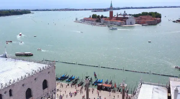 Vista aerea di Venezia con l'isola di San Giorgio in lontananza, gondole e piazza San Marco in primo piano.