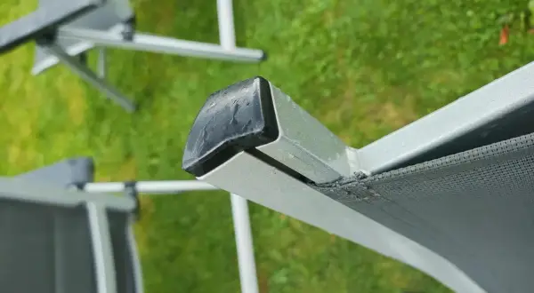 Nahaufnahme eines beschädigten Gartenstuhl PVC Bespannung. Die Reparatur ist dringend nötig, um den Stuhl wieder nutzbar zu machen.