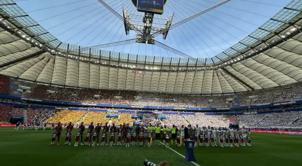 Piłkarze i dzieci stoją na murawie stadionu przed meczem Pucharu Polski.