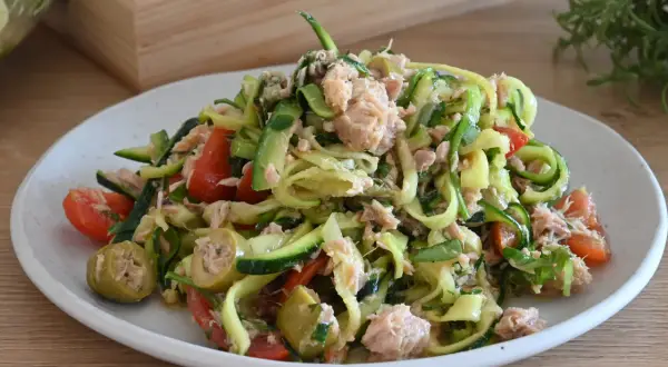 Deliziosa insalata di zucchine crude a spirale con tonno, pomodorini e olive verdi. Un piatto fresco e leggero.