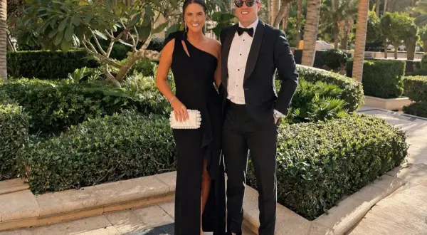 Ett par klädda för en black tie-kväll, hon i en elegant svart klänning, han i smoking.