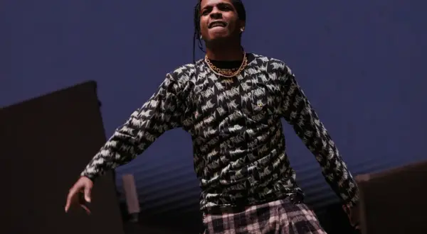 ASAP Rocky opener na scenie, w bluzie z nadrukiem i kratową spódnicą.