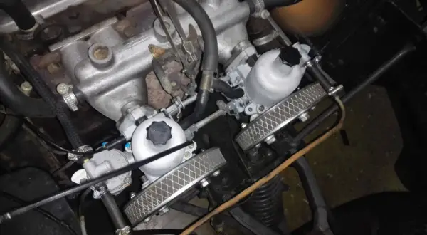 Detalle del motor de un coche clásico con doble carburador, listo para dar potencia.