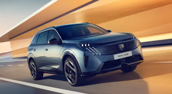 En blå Peugeot E-5008 glider fram på en väg, redo för ett spännande peugeot 5008 test.