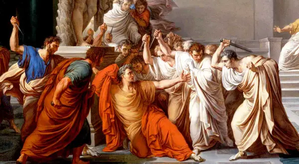 Män i toga omringar och attackerar Julius Caesar med knivar.
