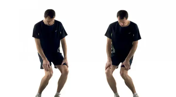 Homme effectuant un exercice de renforcement du genou, en position accroupie avec les mains sur les genoux.