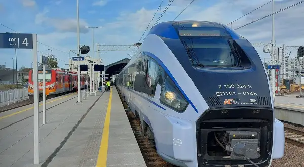 Nowoczesny pociąg Intercity stoi na peronie 4. Obok inny skład czeka na pasażerów.