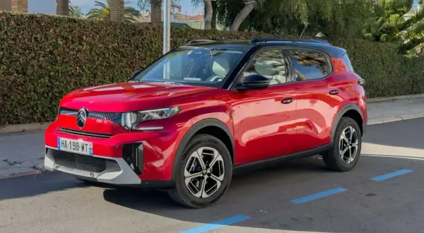 Czerwony Citroën C3 Aircross zaparkowany na ulicy, z widocznym przodem i bokiem.