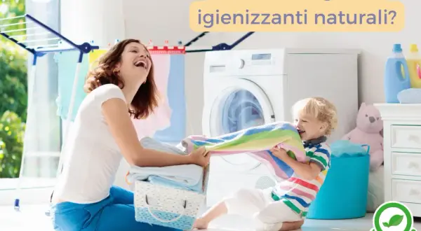 Mamma e bambino giocano con i panni colorati vicino alla lavatrice. Un invito a scegliere igienizzanti naturali per il lavaggio.