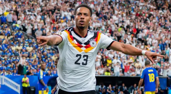 Fußballer Felix Nmecha im Deutschland-Trikot mit der Nummer 23, jubelt vor einer Menge.