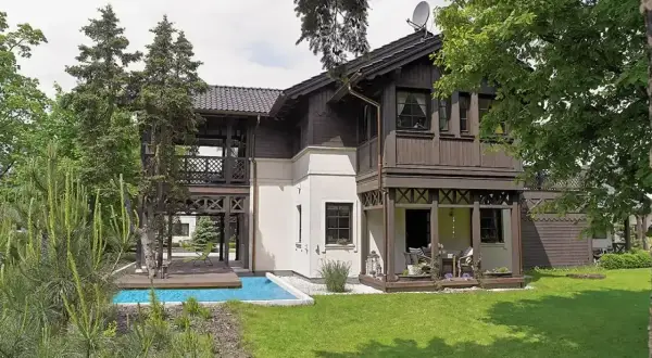 Elegancki świdermajer otwocki z basenem i tarasem, otoczony zielenią.