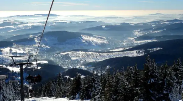Blick vom Sessellift im Rokytnice Skigebiet auf verschneite Berge und Täler.