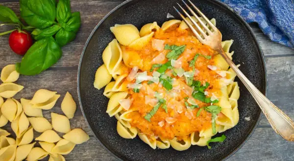 Schalen-Nudeln mit cremiger Tomaten-Sahne-Sauce, garniert mit Basilikum und Parmesan. Ein Genuss!