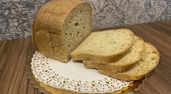 Pyszny keto chleb, idealny na śniadanie. Kromki ułożone na złotej paterze z koronkową serwetką.