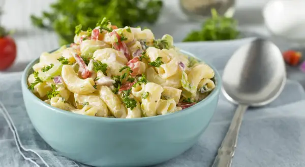 Cremiger Nudelsalat mit Joghurt, garniert mit frischer Petersilie. Perfekt für ein leichtes Mittagessen.