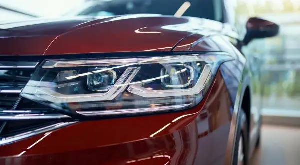 Detalle de faro de coche rojo con luces LED y catadióptricos que reflejan la luz.