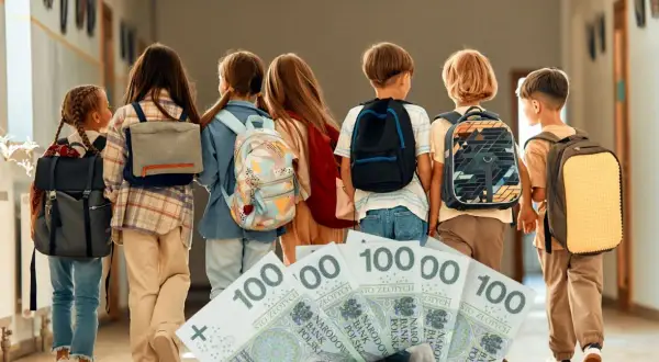 Dzieci z plecakami idą korytarzem, a przed nimi leżą banknoty 100 zł. Zastanawiamy się, ile szkoła dostaje za dziecko z orzeczeniem.