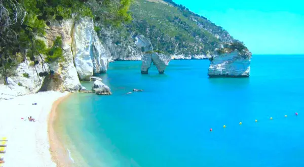 Spiaggia con faraglioni nel mare cristallino del Gargano.