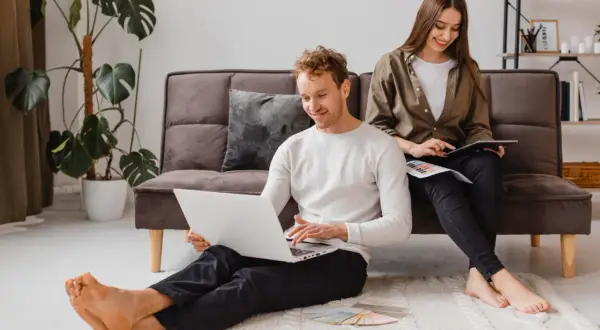 Para młodych planuje swoje wymarzone mieszkanie na start, korzystając z laptopa i tabletu.