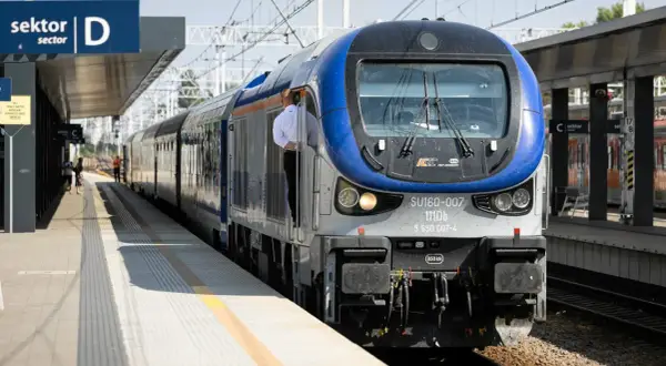 Pociąg PKP Intercity na dworcu PKP Ełk. Maszynista w białej koszuli czeka na odjazd.