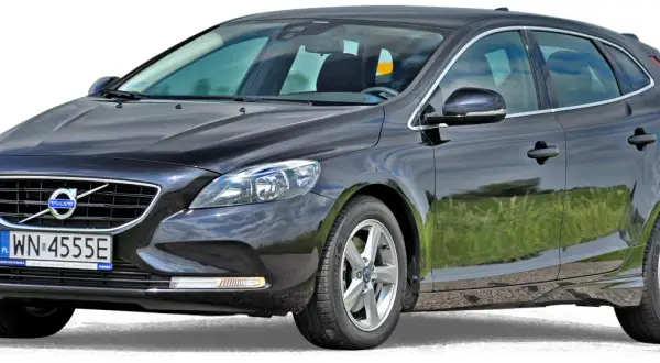 Czarne volvo hatchback z polskimi tablicami rejestracyjnymi WN 4555E, zaparkowane na tle zielonej trawy.