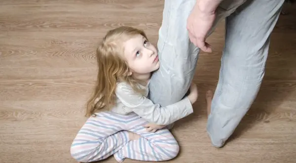 Liten flicka kramar ett ben, hennes blick uppåt. Kanske en bild som illustrerar hur narcissistiska barn kan söka uppmärksamhet.
